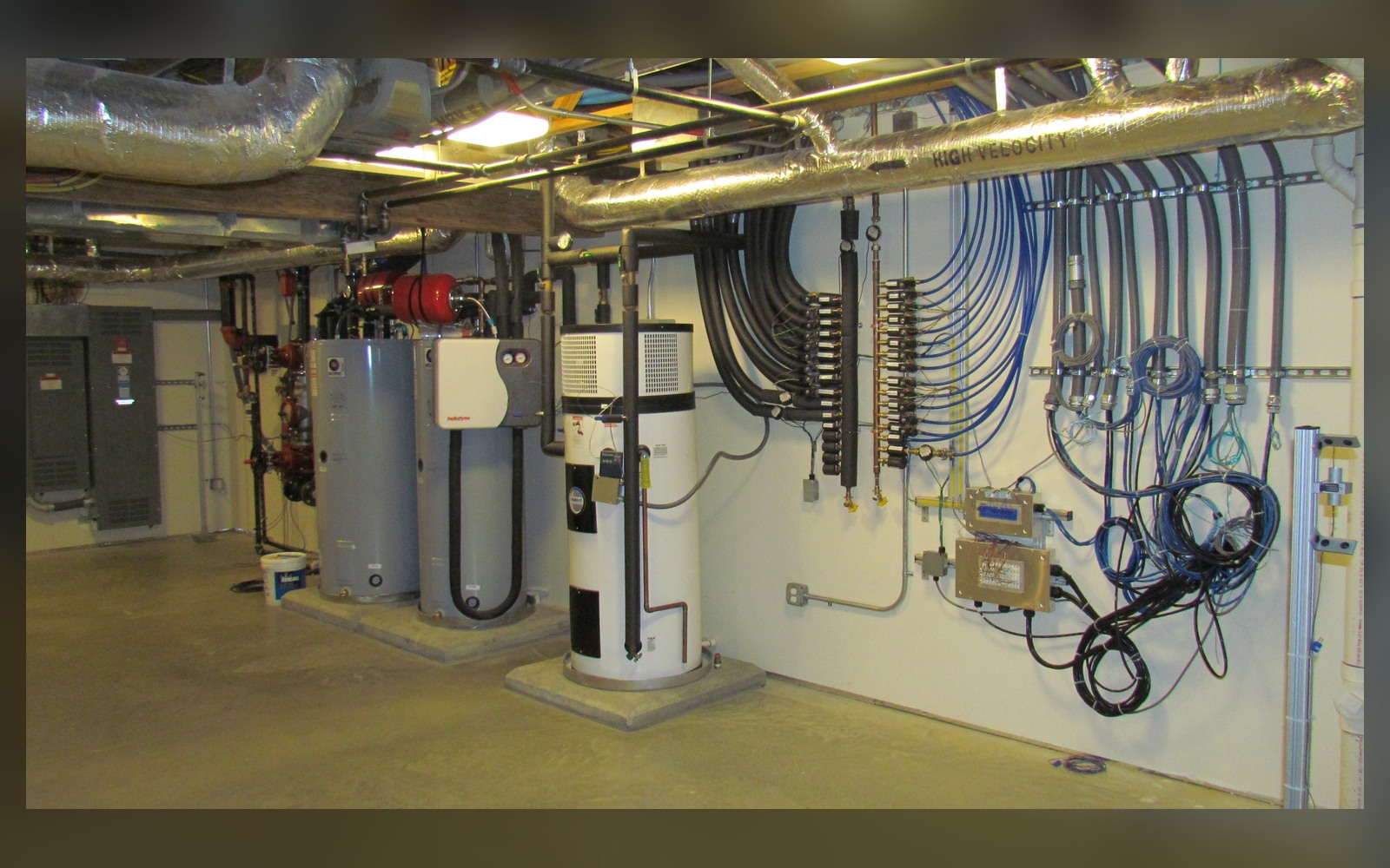 Modern heat-pump water heater in a clean residential utility room