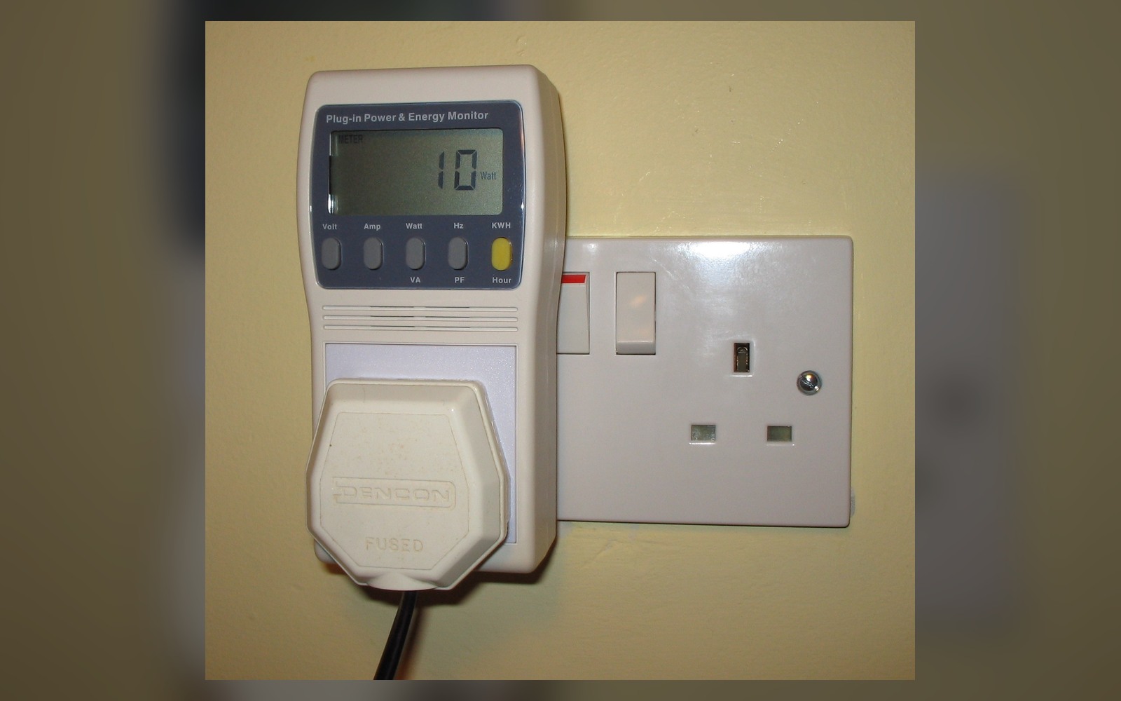 Plug-in electricity monitor showing live appliance energy use in a UK socket