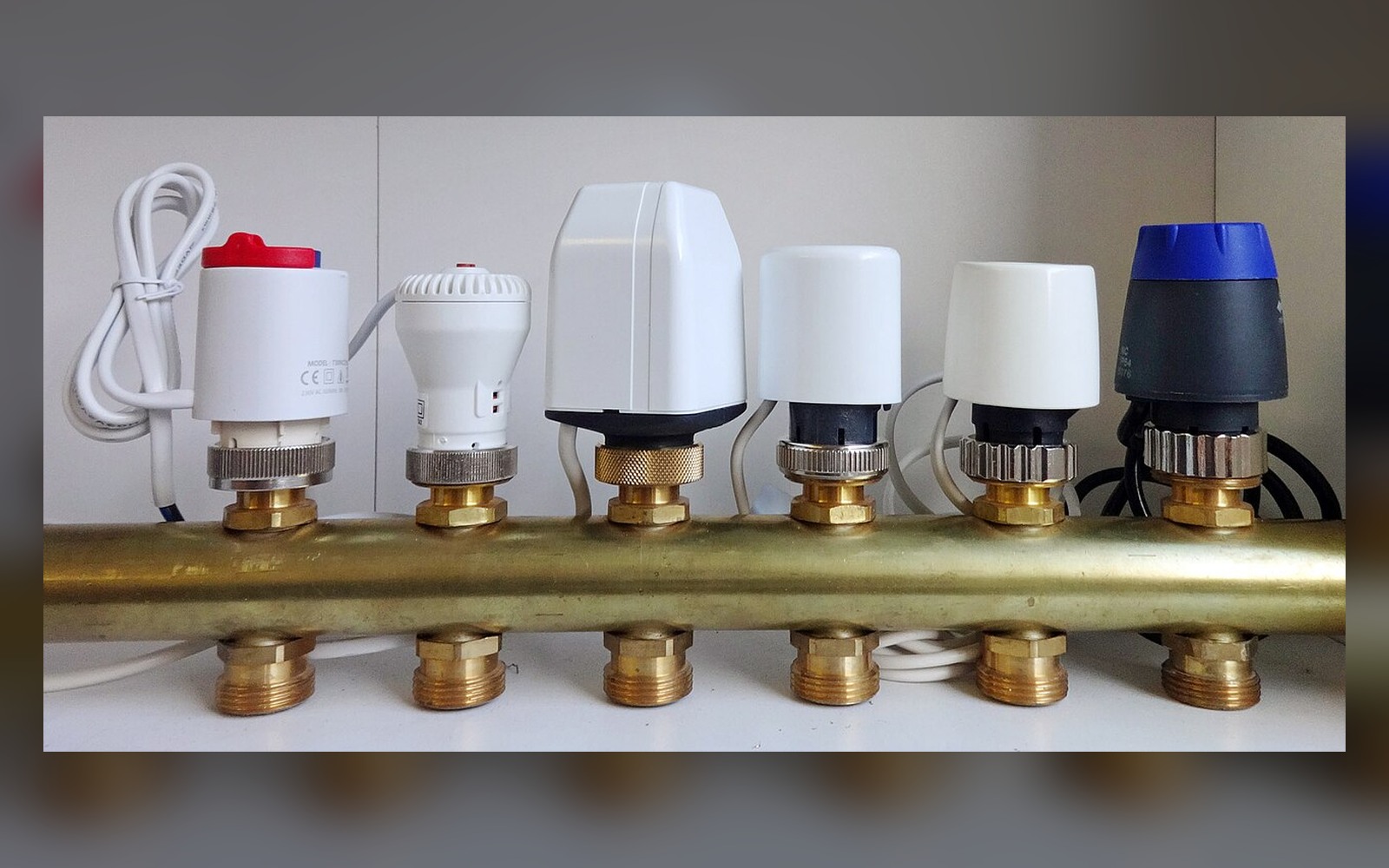 Several electrothermal actuators mounted on an underfloor-heating manifold